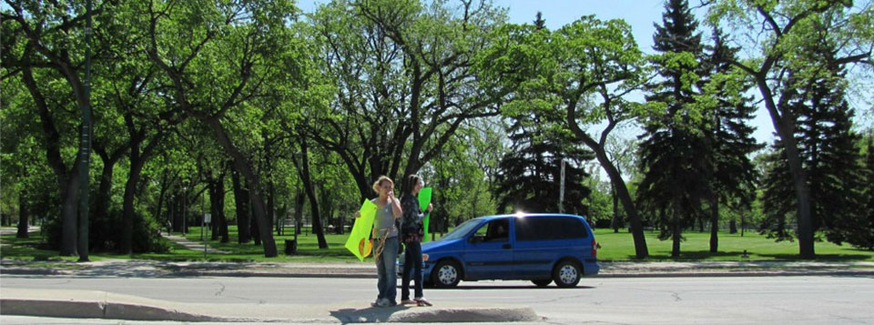 Students stand on the Main Street median to bring in customers for the annual Grad BBQ. Funds raised go to a local charity.